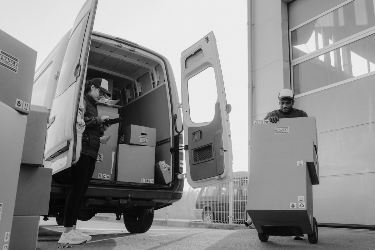 Delivery workers unloading parcels from a van at a distribution centre